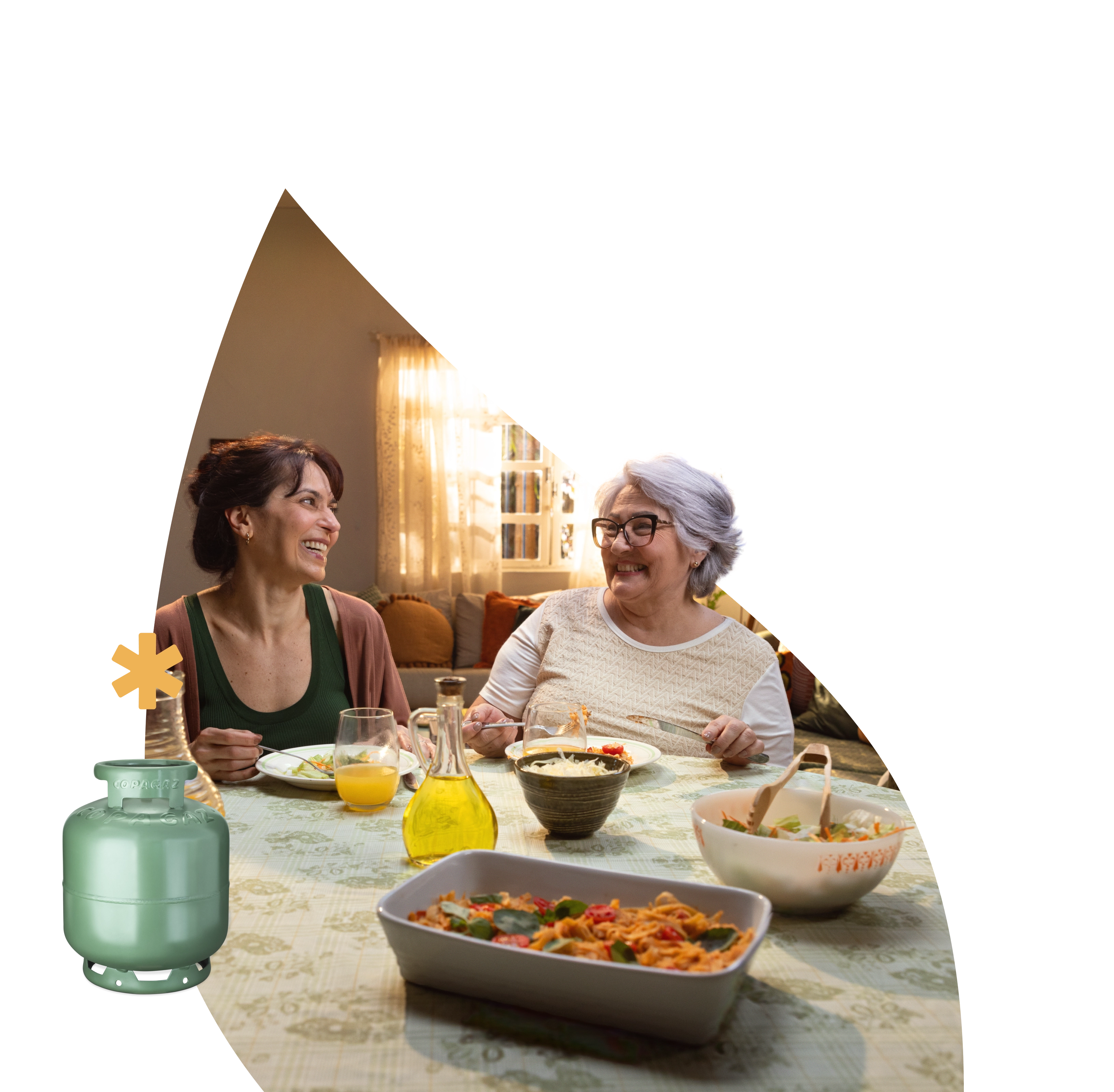 Duas mulheres sorrindo em uma mesa de jantar com pratos de comida, simbolizando momentos acolhedores proporcionados pela Copagaz.