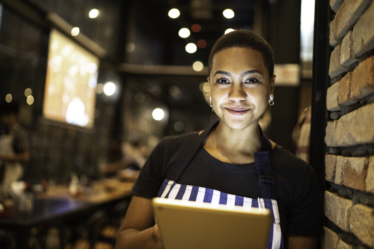 Dona da pizzaria sorrindo para foto