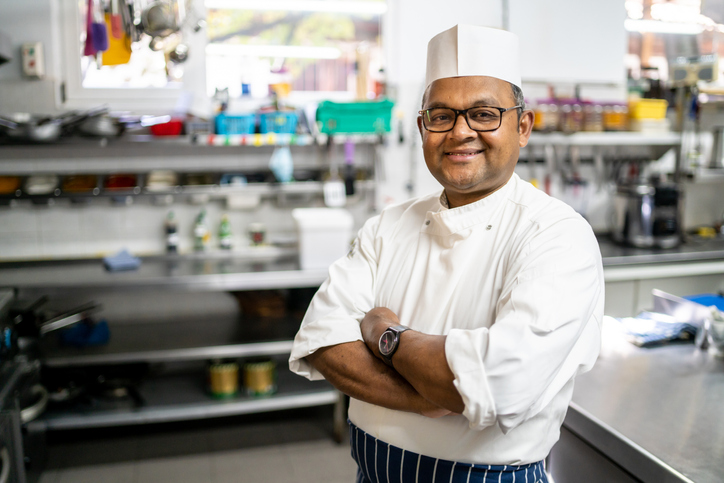 Chefe de cozinha da espetaria sorrindo para a câmera