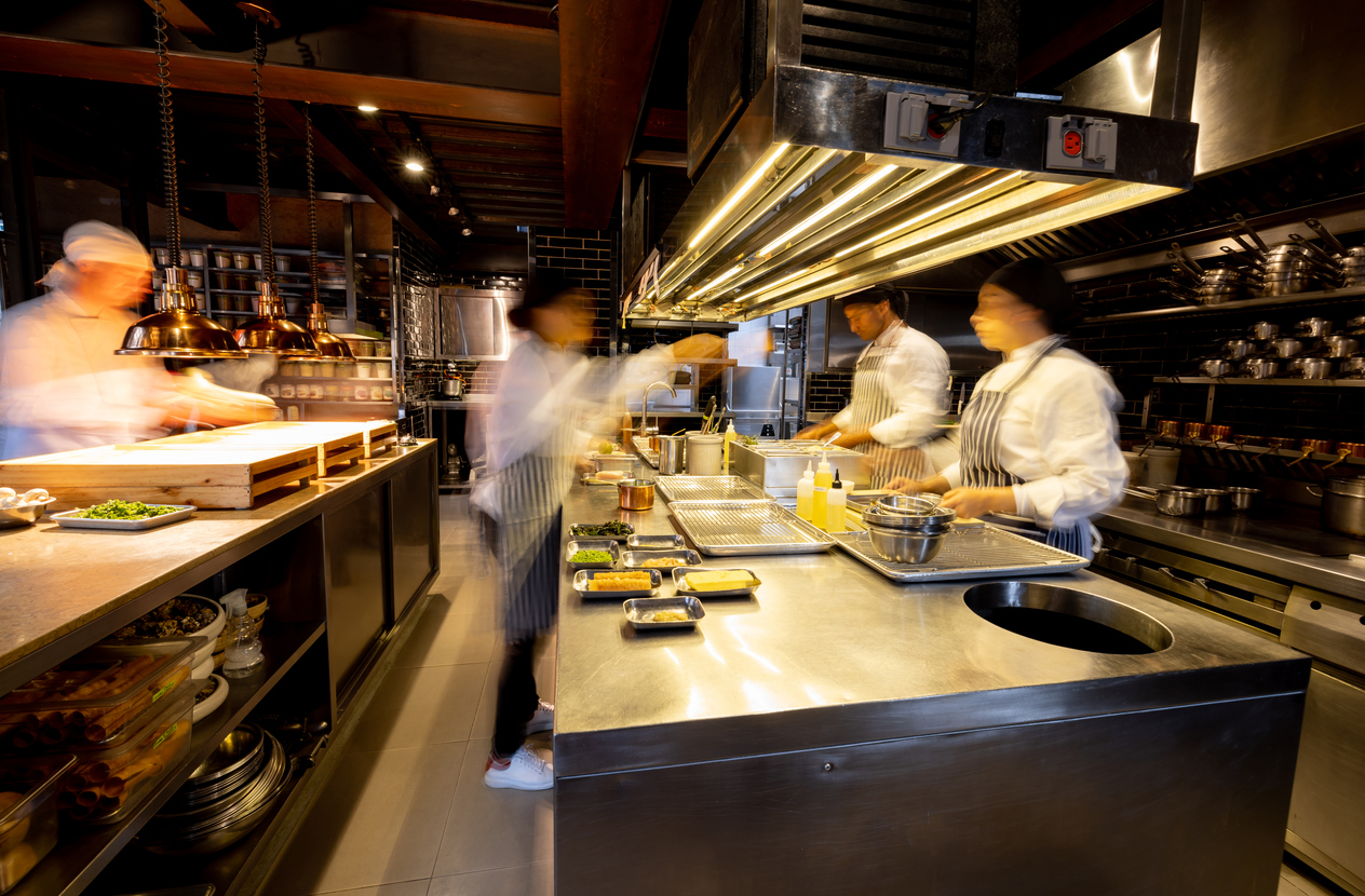 Cozinheiros agitados trabalhando em uma cozinha industrial