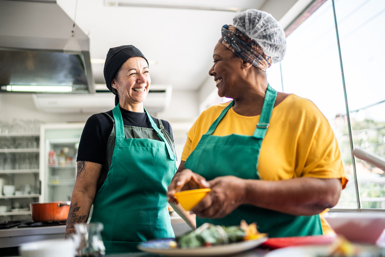 Alunos fazendo um prato em uma aula de culinária