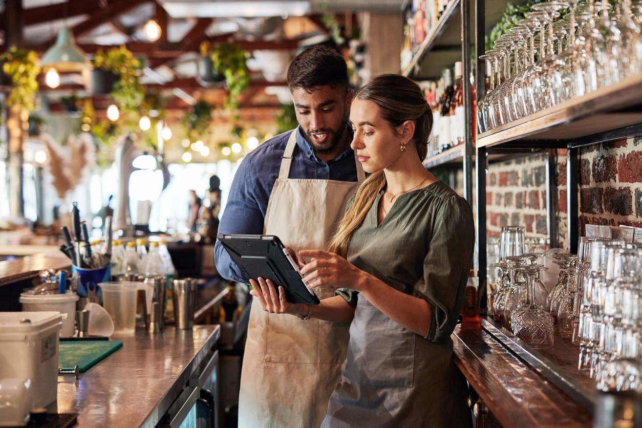 Barman e dona do restaurante vendo o tablet