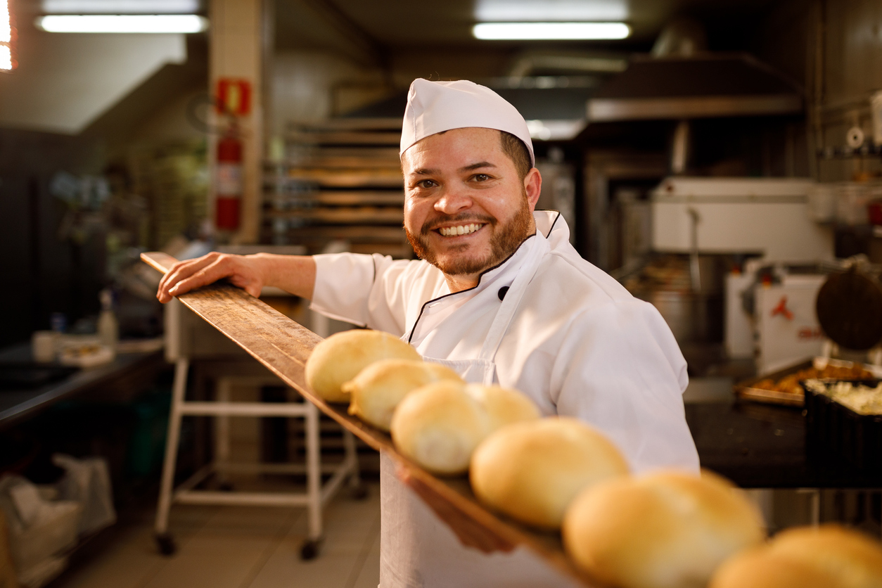 Padeiro sorridente com os pães prontos